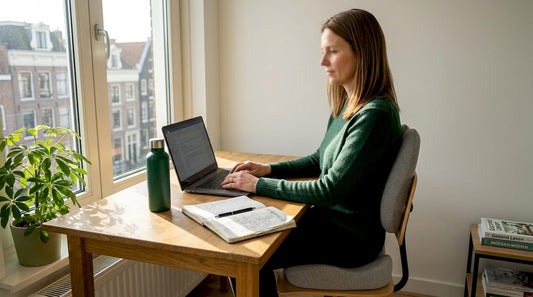Een vrouw werkt comfortabel en ergonomisch in haar gezellige thuiswerkplek.